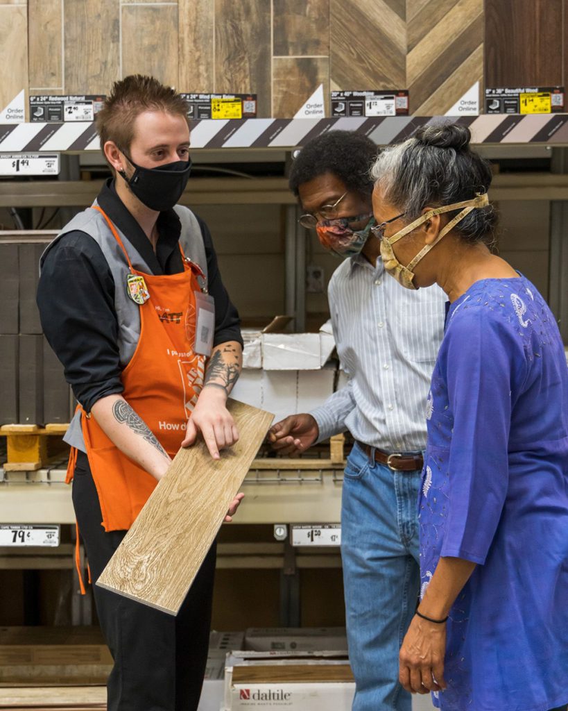 people being shown flooring at The Home Depot