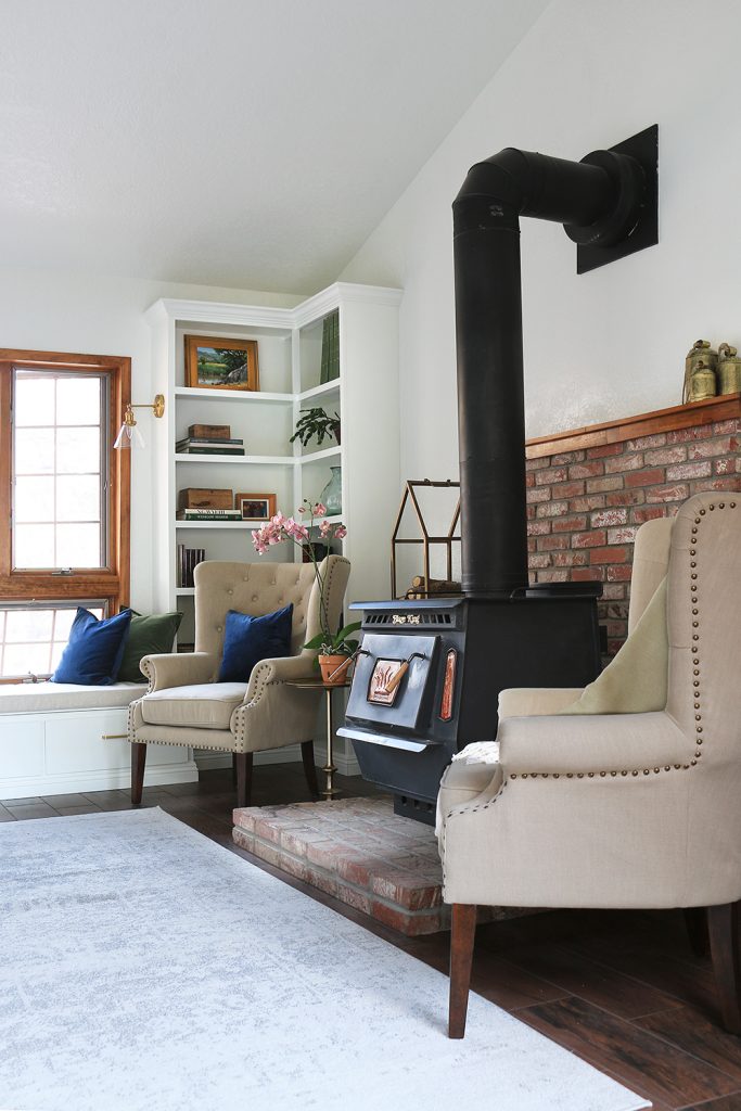 high back armchairs next to a wood burning stove