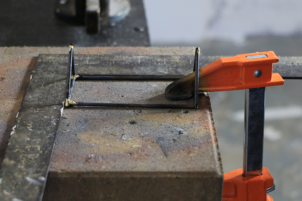 clamp holding geometric metal piece